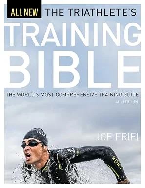 Cover of The Triathlete’s Training Bible by Joe Friel, showing an athlete leaving the water after the swim